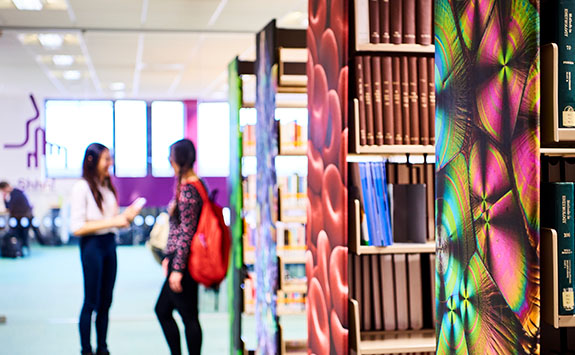 Students and bookshelves in the Walton Library